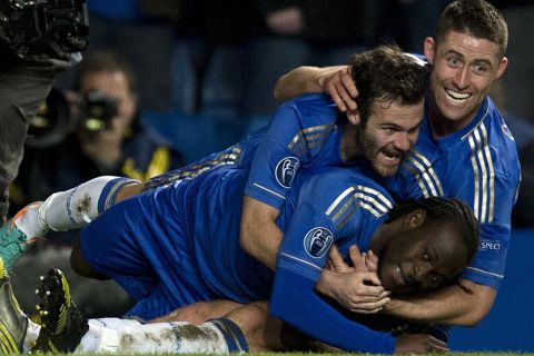 Chelsea's Nigerian player Victor Moses (bottom) is jumped on by teammates Gary Cahill (R) and Juan Mata (C) after he scored the winning goal against Shakhtar Donetsk during the UEFA Champions League Group E football match against at Stamford Bridge in London on November 7, 2012. Chelsea won the game 3-2. AFP PHOTO / ADRIAN DENNIS        (Photo credit should read ADRIAN DENNIS/AFP/Getty Images)