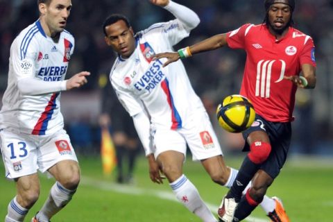 Lille's Ivorian forward Gervinho (R) vies with Lyon's defender Anthony Reveillere (L) and forward Jimmy Briand (C) during their French L1 football match Lille vs. Lyon on February 27, 2011 at the Lille metropole stadium in Villeneuve d'Ascq. AFP PHOTO PHILIPPE HUGUEN (Photo credit should read PHILIPPE HUGUEN/AFP/Getty Images)