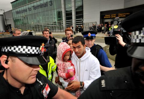 Police escort Manchester City's Argentinian footballer Carlos Tevez (C) as he arrives with his family at Manchester airport in north-west England, on February 14, 2012. Carlos Tevez arrived back in England Tuesday accusing Manchester City manager Roberto Mancini of treating him "like a dog" in the incident that led to his exile from the Premier League leaders. Tevez hasn't played for City since that September 27 match in Germany but is due to return to Eastlands on Tuesday in a bid to revive a career that has effectively been suspended for more than three months. AFP PHOTO/BEN STANSALL (Photo credit should read BEN STANSALL/AFP/Getty Images)