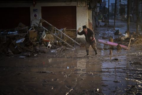 A woman tries to walk through the mud after the floods in Alfafar, Valencia, Spain, Wednesday, Nov. 6, 2024. (AP Photo/Emilio Morenatti)