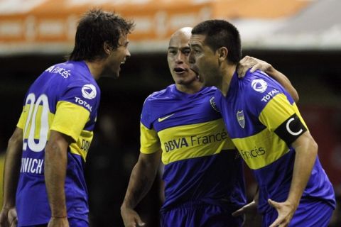 Juan Roman Riquelme (R) of Argentina's Boca Juniors and his teammates Clemente Rodriguez (C) and Dario Cvitanich celebrate their team's goal against Chile's Union Espanola during their Copa Libertadores soccer match in Buenos Aires May 2, 2012. REUTERS/Enrique Marcarian (ARGENTINA - Tags: SPORT SOCCER)