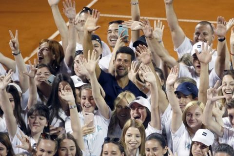 FILE - In this Sunday, June 14, 2020 file photo, Serbia's Novak Djokovic, centre, poses with volunteers and players after the Adria Tour charity tournament in Belgrade, Serbia. Novak Djokovic has tested positive for the coronavirus after taking part in a tennis exhibition series he organized in Serbia and Croatia. The top-ranked Serb is the fourth player to test positive for the virus after first playing in Belgrade and then again last weekend in Zadar, Croatia. His wife also tested positive. (AP Photo/Darko Vojinovic, File)