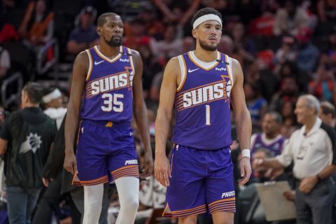 Phoenix Suns forward Kevin Durant (35) and guard Devin Booker (1) during an NBA basketball game against the Dallas Mavericks Saturday, Oct. 26, 2024, in Phoenix. (AP Photo/Darryl Webb)