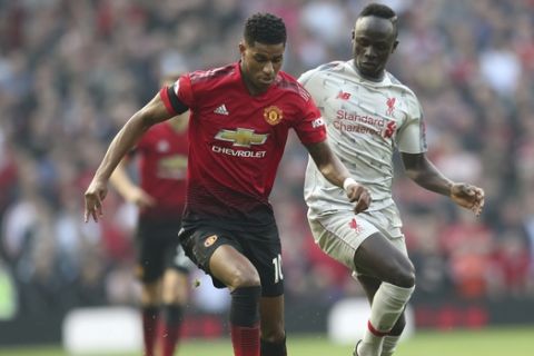 Manchester United's Marcus Rashford, left, and Liverpool's Sadio Mane challenge for the ball during the English Premier League soccer match between Manchester United and Liverpool at Old Trafford stadium in Manchester, England, Sunday, Feb. 24, 2019. (AP Photo/Jon Super)