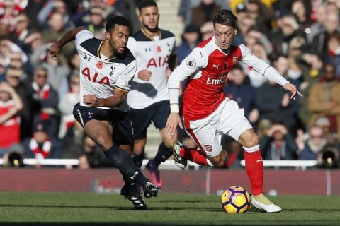 Arsenal's Mesut Ozil, right, vies for the ball with Tottenham's Mousa Dembele during the English Premier League soccer match between Arsenal and Tottenham Hotspur at Emirates stadium in London, Sunday, Nov. 6, 2016. (AP Photo/Kirsty Wigglesworth)