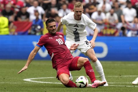 Serbia's Dusan Tadic, left, and Slovenia's Zan Karnicnik fight for the ball during a Group C match between Slovenia and Serbia at the Euro 2024 soccer tournament in Munich, Germany, Thursday, June 20, 2024. (AP Photo/Antonio Calanni)