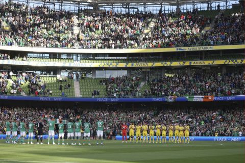 Players and fans holding a minute of silence to protest against Russia's war in Ukraine prior the UEFA Nations League soccer match between Ireland and Ukraine at the Aviva Stadium in Dublin, Ireland, Wednesday, June 8, 2022. (AP Photo/Peter Morrison)