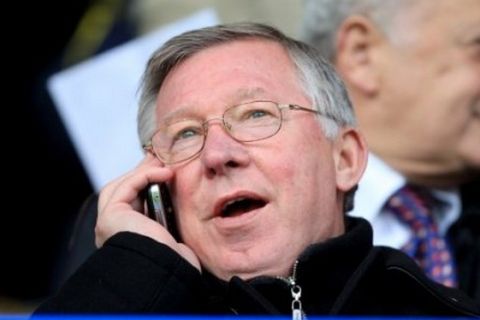 Manchester United manager Alex Ferguson on the phone in the stands