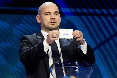 Former soccer player Wesley Sneijder holds up the name Denmark during the draw for the UEFA Euro 2024 soccer tournament finals in Hamburg, Germany, Saturday, Dec. 2, 2023. (AP Photo/Martin Meissner)