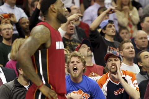 Cleveland Cavaliers fans yell at Miami Heat's LeBron James (L) during the fourth quarter of their NBA basketball game in Cleveland March 29, 2011.REUTERS/Aaron Josefczyk (UNITED STATES - Tags: SPORT BASKETBALL)