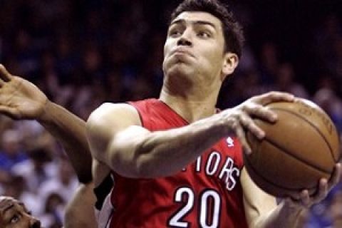 Toronto Raptors guard Carlos Delfino (20), of Argentina, gets around Orlando Magic center Dwight Howard for a shot during the first half of Game 2 in an NBA Eastern Conference  playoff basketball series in Orlando, Fla., Tuesday, April 22, 2008.(AP Photo/John Raoux)