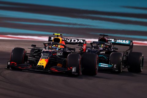 ABU DHABI, UNITED ARAB EMIRATES - DECEMBER 12: Sergio Perez of Mexico driving the (11) Red Bull Racing RB16B Honda leads Lewis Hamilton of Great Britain driving the (44) Mercedes AMG Petronas F1 Team Mercedes W12 during the F1 Grand Prix of Abu Dhabi at Yas Marina Circuit on December 12, 2021 in Abu Dhabi, United Arab Emirates. (Photo by Clive Rose/Getty Images)