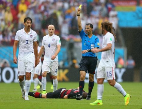 RECIFE, BRAZIL - JUNE 26:  Omar Gonzalez of the United States is shown a yellow card by referee Ravshan Irmatov after a foul on Bastian Schweinsteiger of Germany during the 2014 FIFA World Cup Brazil group G match between the United States and Germany at Arena Pernambuco on June 26, 2014 in Recife, Brazil.  (Photo by Michael Steele/Getty Images)