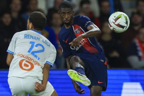 PSG's Ousmane Dembele, right, and Marseille's Renan Lodi vie for the ball during the French League One soccer match between Paris Saint Germain and Olympique de Marseille at Parc des Princes stadium in Paris, France, Sunday, Sept. 24, 2023. (AP Photo/Aurelien Morissard)