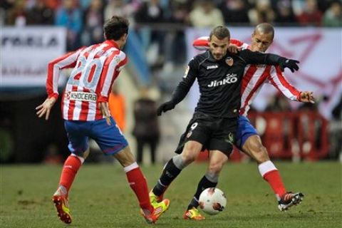 Valencia's Roberto Soldado, center, gets between Atletico de Madrid's Juan Francisco Torres, left, and Joao Miranda of Brazil, right, during a Spanish La Liga soccer match at the Vicente Calderon stadium in Madrid, Sunday, Feb. 5, 2012. (AP Photo/Arturo Rodriguez)