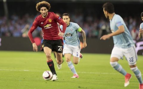 Manchester United's Marouane Fellaini, left, runs ahead of Celta's Hugo Mallo during a Europa League, semifinal, first leg soccer match between Celta and Manchester United at the Balaidos stadium in Vigo, Spain, Thursday May 4, 2017. (AP Photo/Lalo R. Villar)