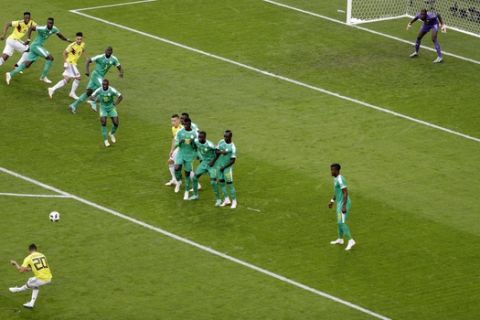 Colombia's Juan Quintero, bottom, kicks the ball during the group H match between Senegal and Colombia, at the 2018 soccer World Cup in the Samara Arena in Samara, Russia, Thursday, June 28, 2018. (AP Photo/Gregorio Borgia)