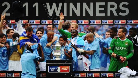 LONDON, ENGLAND - MAY 14:  Carlos Tevez celebrates with the trophy after he and his Manchester City team mates win the FA Cup sponsored by E.ON Final match between Manchester City and Stoke City at Wembley Stadium on May 14, 2011 in London, England.  (Photo by Mike Hewitt/Getty Images)