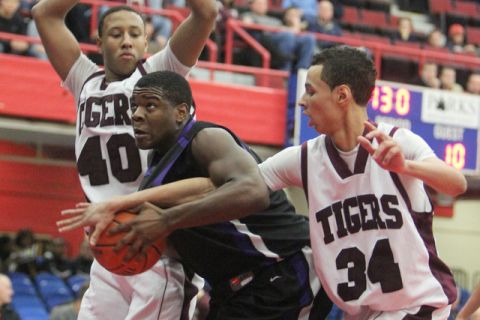 New Rochelle's Joseph Clarke, center, is guarded by Kingston's DJ Mapes, left, and Deion Monroe during their Slam Dunk tournament game at the Westchester County Center Dec. 28, 2011. Kingston won 57-55. ( Peter Carr / The Journal News )