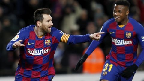 Barcelona's Lionel Messi, left, celebrates with Ansu Fati after scoring the opening goal during a Spanish La Liga soccer match between Barcelona and Granada at Camp Nou stadium in Barcelona, Spain, Sunday, Jan. 19, 2020. (AP Photo/Joan Monfort)