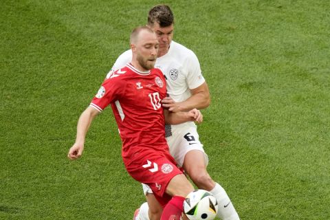 Denmark's Christian Eriksen, left, vies for the ball with Slovenia's Jaka Bijol during a Group C match between Slovenia and Denmark at the Euro 2024 soccer tournament in Stuttgart, Germany, Sunday, June 16, 2024. (AP Photo/Ariel Schalit)