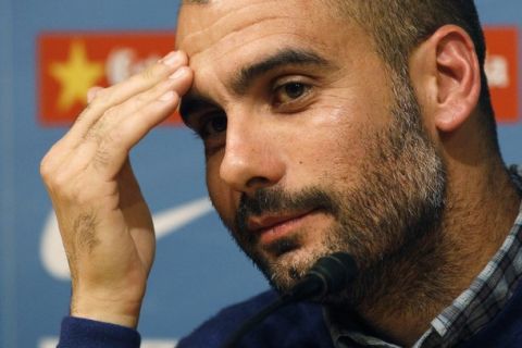 Barcelona's coach Pep Guardiola listens during a news conference at Nou Camp stadium in Barcelona April 15, 2011. Barcelona and Real Madrid will play their Spanish first division "clasico" soccer match on Saturday.    REUTERS/Gustau Nacarino(SPAIN - Tags: SPORT SOCCER)