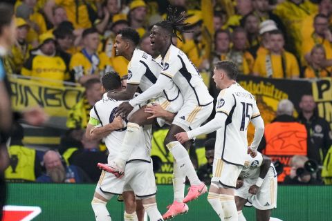 Real Madrid players celebrate their side's first foal scored by Dani Carvajal during the Champions League final soccer match between Borussia Dortmund and Real Madrid at Wembley stadium in London, Saturday, June 1, 2024. (AP Photo/Kirsty Wigglesworth)