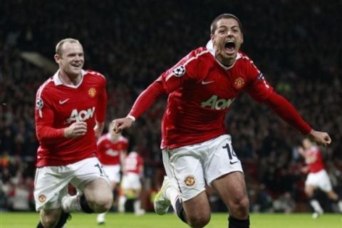 Manchester United's Javier Hernandez, right, celebrates with team mate Wayne Rooney after scoring a goal against Chelsea during their Champions League quarterfinal second leg soccer match at Old Trafford, Manchester, England, Tuesday, April 12, 2011. (AP Photo/Jon Super)