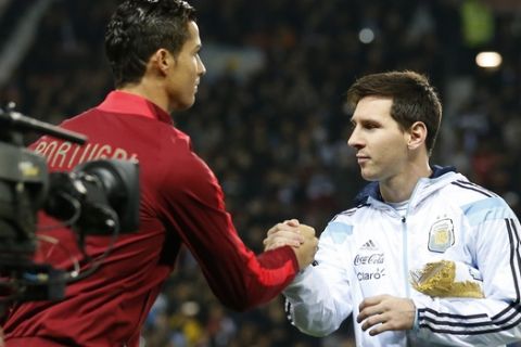 Lionel Messi of Argentina, right, greets Cristiano Ronaldo of Portugal before their International Friendly soccer match at Old Trafford Stadium, Manchester, England, Tuesday Nov. 18, 2014. (AP Photo/Jon Super)  