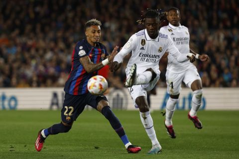 Real Madrid's Eduardo Camavinga, right, is challenged by Barcelona's Raphinha during the Spanish Copa del Rey semi final, second leg soccer match between Barcelona and Real Madrid at the Camp Nou stadium in Barcelona, Spain, Wednesday, April 5, 2023. (AP Photo/Joan Monfort)