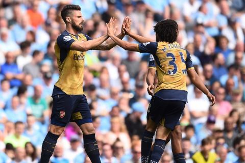 MANCHESTER, ENGLAND - MAY 08:  Olivier Giroud of Arsenal (L) celebrates scoring his side's first goal with Mohamed Elneny of Arsenal during the Barclays Premier League match between Manchester City and Arsenal at the Etihad Stadium on May 8, 2016 in Manchester, England.  (Photo by Laurence Griffiths/Getty Images)