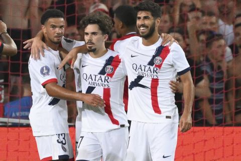 PSG's Vitinha, 2nd right, celebrates after scoring the opening goal from the penalty spot during the French League 1 soccer match between Lille and Paris Saint-Germain, in Villeneuve-d'Ascq, France, Sunday, Sept. 1, 2024. (AP Photo/Matthieu Mirville)