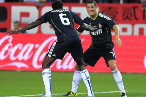 Real Madrid's Cristiano Ronaldo (R) celebrates his third goal against Sevilla with team mate Emmanuel Adebayor during their Spanish First Division soccer match at Ramon Sanchez Pizjuan stadium in Seville May 7, 2011.   REUTERS/Javier Diaz (SPAIN - Tags: SPORT SOCCER)