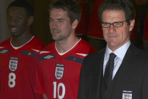 The England national soccer team manager Fabio Capello of Italy, right, and players Shaun Wright-Phillips and Michael Owen pose for photographers to launch the team's new away strip in at a hotel near Watford, England, Monday Feb. 4, 2008.  England play Switzerland in a friendly match at Wembley stadium on Wednesday.  (AP Photo/Matt Dunham)