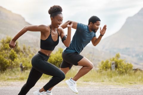 Fit african american couple running outdoors while exercising. Young athletic man and woman training to improve their cardio and endurance for a healthy lifestyle. They love to workout together