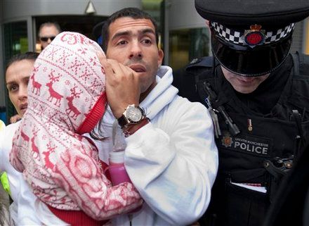 Footballer Carlos Tevez arrives at Manchester Airport, Manchester, England, Tuesday, Feb. 14, 2012. Its is reported that Tevez, who has been in Argentina without his club's permission since November 7, will resume his Manchester City career despite accusing manager Roberto Mancini of treating him "like a dog" in the incident that sparked their rift. (AP Photo/Jon Super)