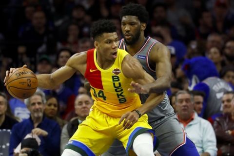 Milwaukee Bucks' Giannis Antetokounmpo, left, tries to drive past Philadelphia 76ers' Joel Embiid during the first half of an NBA basketball game, Thursday, April 4, 2019, in Philadelphia. (AP Photo/Matt Slocum)