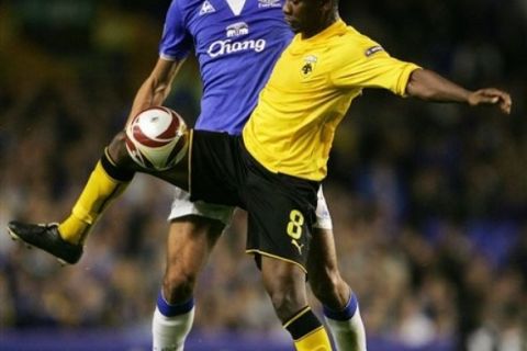 Everton's Marouane Fellaini vies for the ball against AEK Athens' Tamandani Nsaliwa, right, during their Europa League group I soccer match at Goodison Park, Liverpool, England, Thursday Sept. 17, 2009. (AP Photo/Tim Hales)