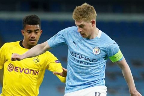 Manchester City's Kevin De Bruyne, right, challenges for the ball with Dortmund's Ansgar Kanuff during the Champions League, first leg, quarterfinal soccer match between Manchester City and Borussia Dortmund at the Etihad stadium in Manchester, Tuesday, April 6, 2021. (AP Photo/Dave Thompson)