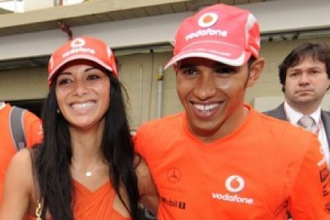 McLaren Mercedes Formula One team driver Lewis Hamilton of Britain leaves the track smiling with his girlfriend, Pussycat Doll singer Nicole Scherzinger, after he secured the 2008 Formula One drivers championship title by finishing fifth during the Brazilian Formula One Grand Prix at the Interlagos circuit in Sao Paulo, Sunday, Nov. 2, 2008. (AP Photo/Oliver Multhaup)