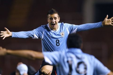 Uruguay's Matias Vecino (C) celebrates with teammate Luis Machado their victory over Argentina in a Conmebol U-20 championship soccer match in Arequipa February 9, 2011.  REUTERS/Mariana Bazo (PERU - Tags: SPORT SOCCER)