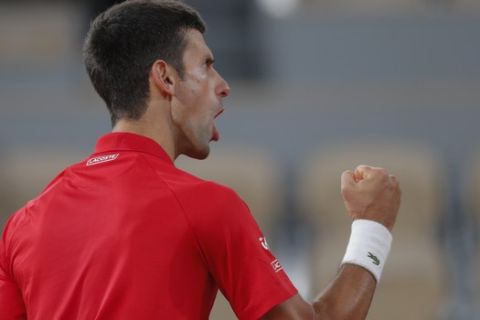 Serbia's Novak Djokovic clenches his fist after scoring a point against Spain's Rafael Nadal in the final match of the French Open tennis tournament at the Roland Garros stadium in Paris, France, Sunday, Oct. 11, 2020. (AP Photo/Michel Euler)