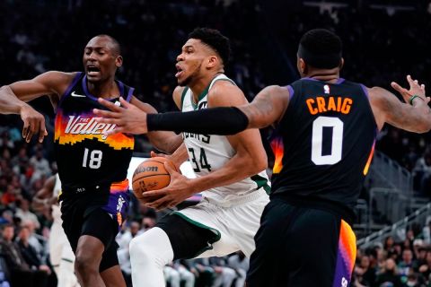 Milwaukee Bucks' Giannis Antetokounmpo drives past Phoenix Suns' Torrey Craig and Bismack Biyombo during the first half of an NBA basketball game Sunday, March 6, 2022, in Milwaukee . (AP Photo/Morry Gash)