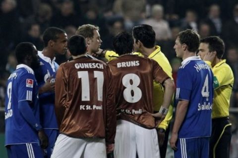 Referee Deniz Aytekin, third right, discusses with players after abandoning the match in 88th minute with Schalke leading 2-0 after the German Bundesliga soccer match between FC St. Pauli and FC Schalke 04 in Hamburg, northern Germany, Friday, April 1, 2011. Aytekin's assistant was hit by a beer mug thrown from the stands. (AP Photo/dapd, Philipp Guelland) NO MOBILE USE UNTIL 2 HOURS AFTER THE MATCH, WEBSITE USERS ARE OBLIGED TO COMPLY WITH DFL-RESTRICTIONS, SEE INSTRUCTIONS FOR DETAILS