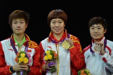 Gold medallist China's Li Xiaoxia (C) poses on the podium after victory in her table tennis women's gold medal singles match against silver medallist Ding Ning of China (L) and bronze medallist Feng Tianwei of Singapore of the London 2012 Olympic Games at The Excel Centre in London on August 1, 2012.  Li won the final 11-8, 14-12, 8-11, 11-6, 11-4.  AFP PHOTO / SAEED KHAN        (Photo credit should read SAEED KHAN/AFP/GettyImages)