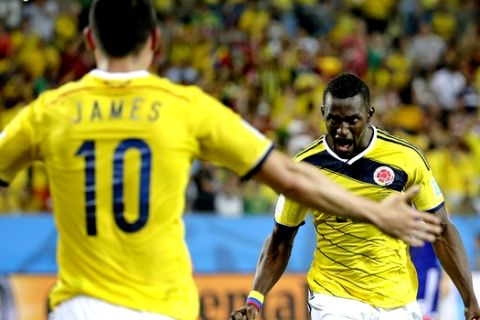 Colombia's Jackson Martinez, right, celebrates with teammate Colombia's James Rodriguez after scoring his teams third goal during the group C World Cup soccer match between Japan and Colombia at the Arena Pantanal in Cuiaba, Brazil, Tuesday, June 24, 2014. (AP Photo/Felipe Dana)