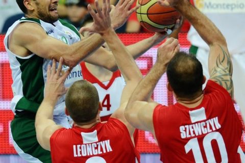 Pawel Leonczyk  and Szewczyk (R) of Poland (DOWN) block Miguel Miranda (L) of Portugal  during the first round group A qualifying match between Poland and Portugal in Panevezys on September 2, 2011, on the third day of the EuroBasket 2011.  AFP PHOTO/JOE KLAMAR (Photo credit should read JOE KLAMAR/AFP/Getty Images)