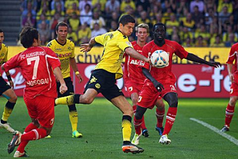 DORTMUND, GERMANY - OCTOBER 01:  Robert Lewandowski of Dortmund (C) scores the first goal against Hajime Hosogai and Gibril Sankoh (R) during the Bundesliga match between Borussia Dortmund and FC Ausgburg at Signal Iduna Park on October 1, 2011 in Dortmund, Germany.  (Photo by Christof Koepsel/Bongarts/Getty Images)