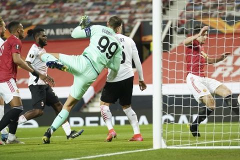 Manchester United's Harry Maguire, right, makes an attempt to score during the Europa League round of 16 first leg soccer match between Manchester United and AC Milan at Old Trafford in Manchester, England, Thursday, March 11, 2021. (AP Photo/Dave Thompson)