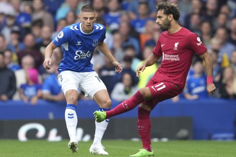 Everton's Vitaliy Mykolenko, left, and Liverpool's Mohamed Salah vie for the ball during the English Premier League soccer match between Everton and Liverpool at Goodison Park, Liverpool, England, Saturday, Sept. 3, 2022. (AP Photo/Jon Super)